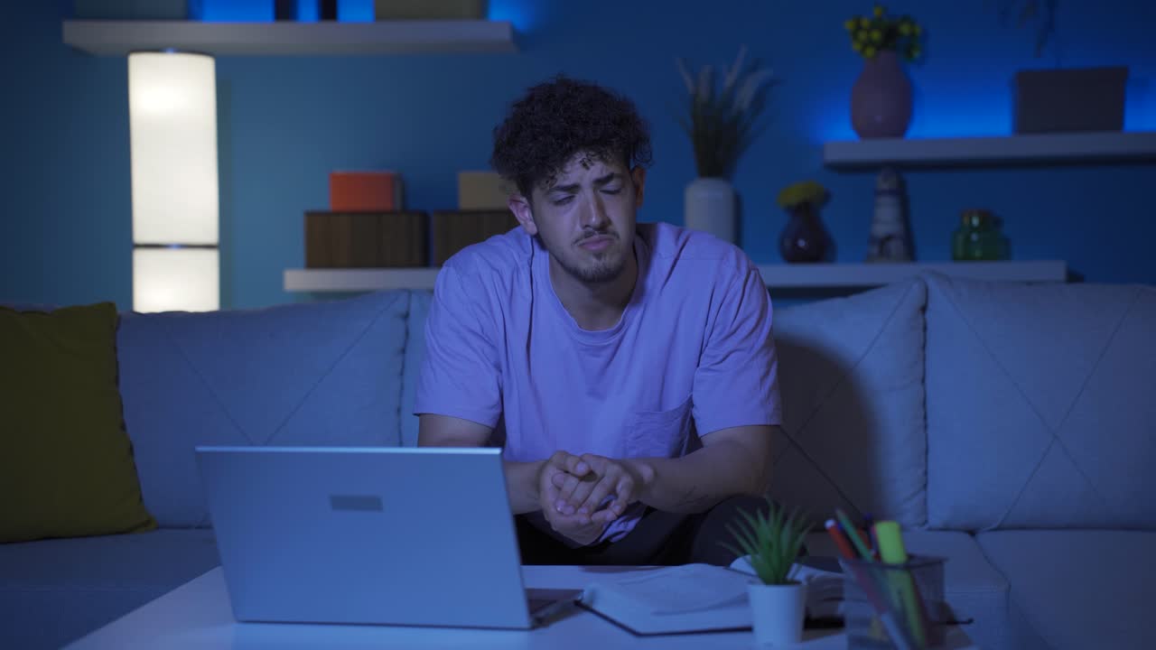 joven solo en casa deprimido y llorando.