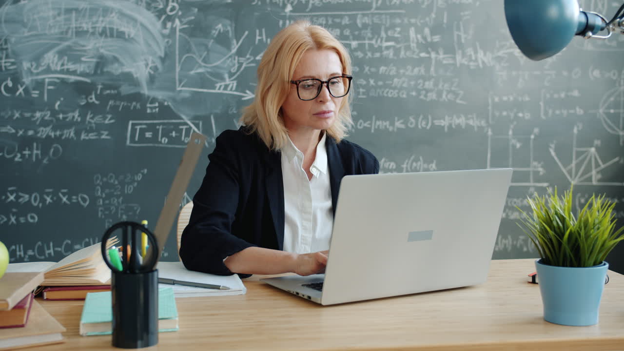 Lehrkraft arbeitet am Laptop im Klassenzimmer