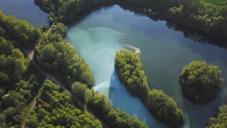 aerial-orbit-view-in-Bochum-Werne,-Germany-nature-with-water-reflections-by-the-sun