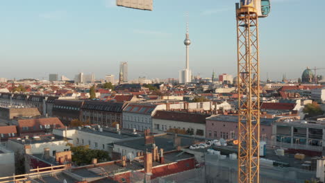 Rising-view-of-cityscape.-Panorama-of-centre-with-Berlin-Cathedral-and-fernsehturm.-Following-yellow-structure-of-truss-column-of-construction-crane.-Berlin,-Germany.