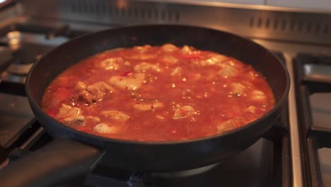 cooking sweet and sour chicken in saucepan - asian styled dish