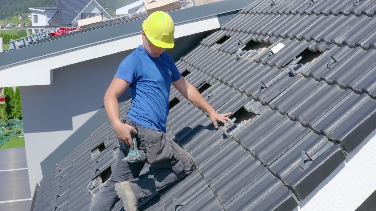 Worker prepares roof of house for installation of solar panels. Slovenia