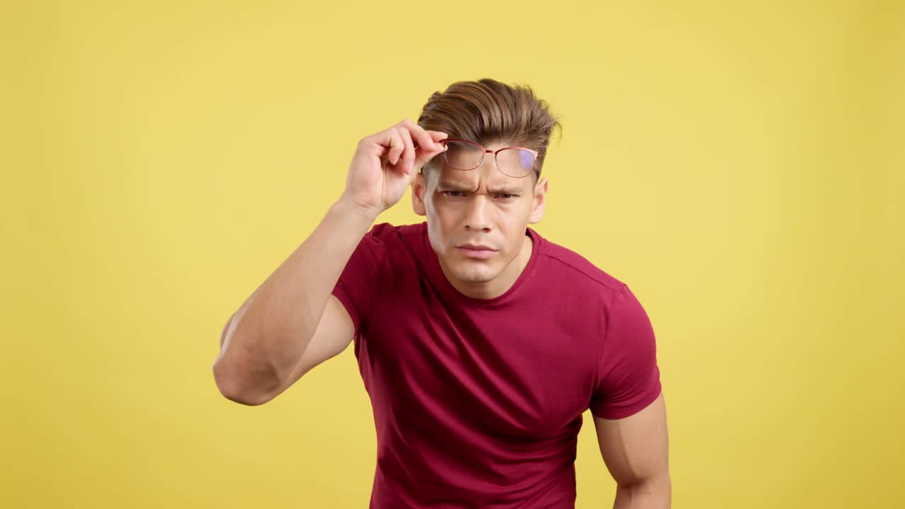 Man with Glasses Adjusting and Peering with a Confused Expression