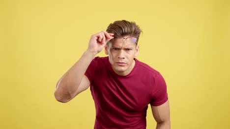 man with glasses adjusting and peering with a confused expression