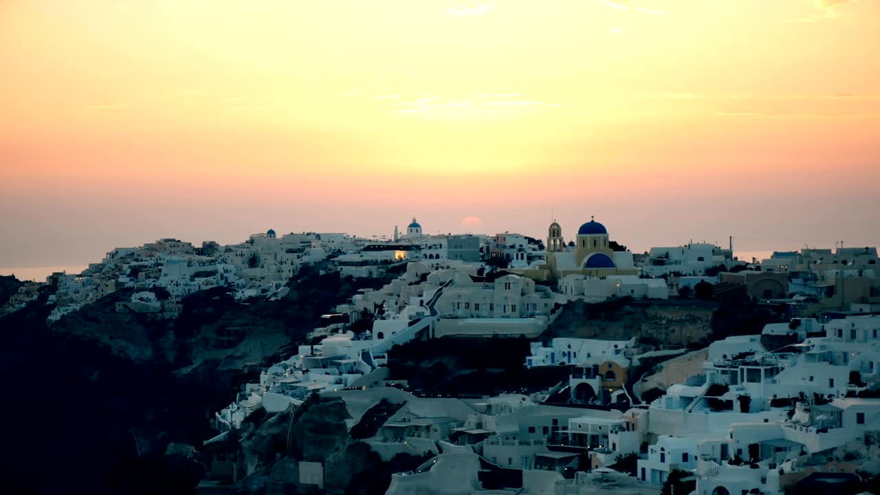 haz un zoom cercano de oia al atardecer en santorini