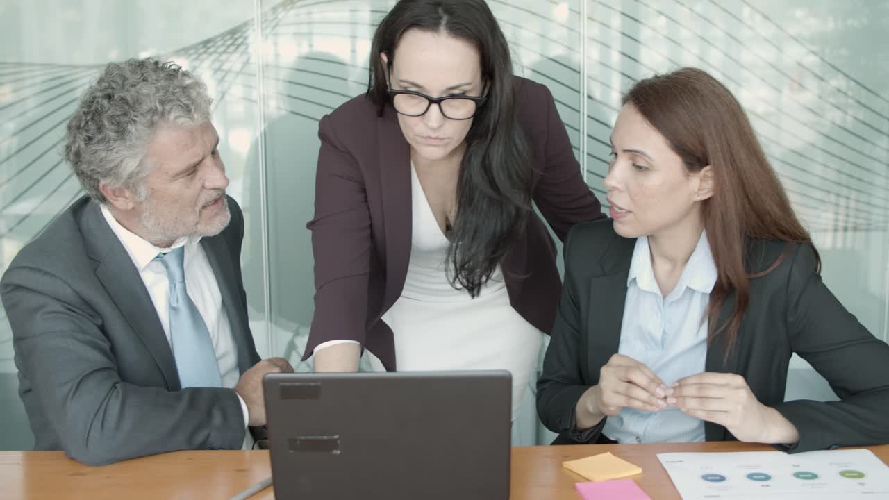 contenido serios colegas viendo la presentación a través de la computadora portátil