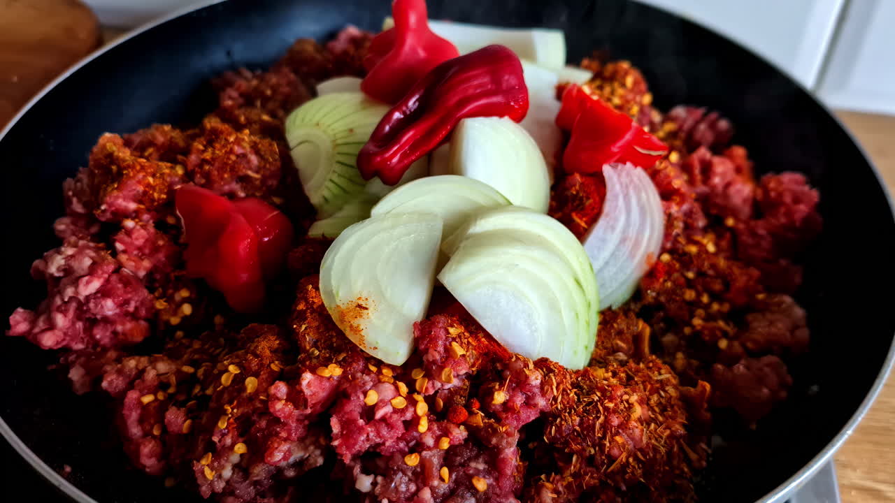 Preparazione di un mix di carne speziata con cipolle e peperoni a Jelgava, in Lettonia