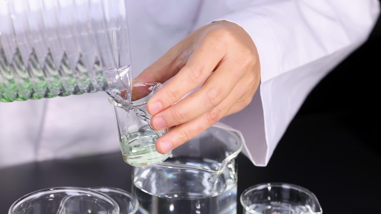 el científico lleva a cabo experimentos con vasos y productos químicos