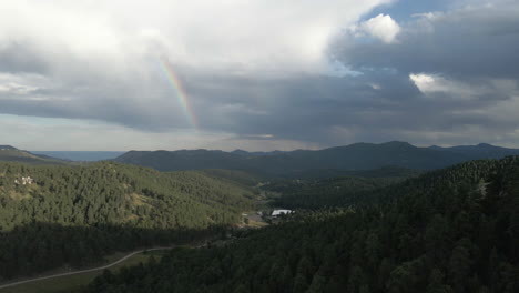 Evergreen-Coniferous-Forest-With-Rainbow-In-The-Background-In-Colorado-Mountains,-United-States
