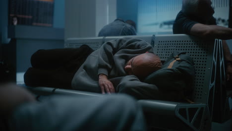 man sleeping in airport waiting area