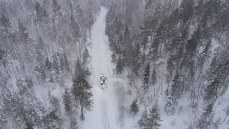 arado de nieve en el bosque lleno de nieve - disparo aéreo de drone