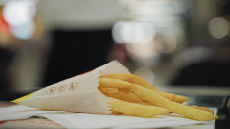 close-up of golden french fries on a table with a blurred background. appetizing appearance of the fries in a casual dining setting