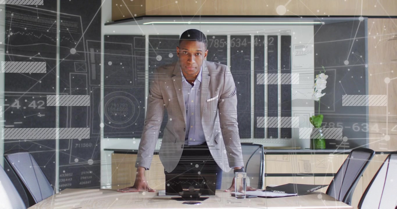 Business executive leaning on table scanning surface and picking up device animating data overlays