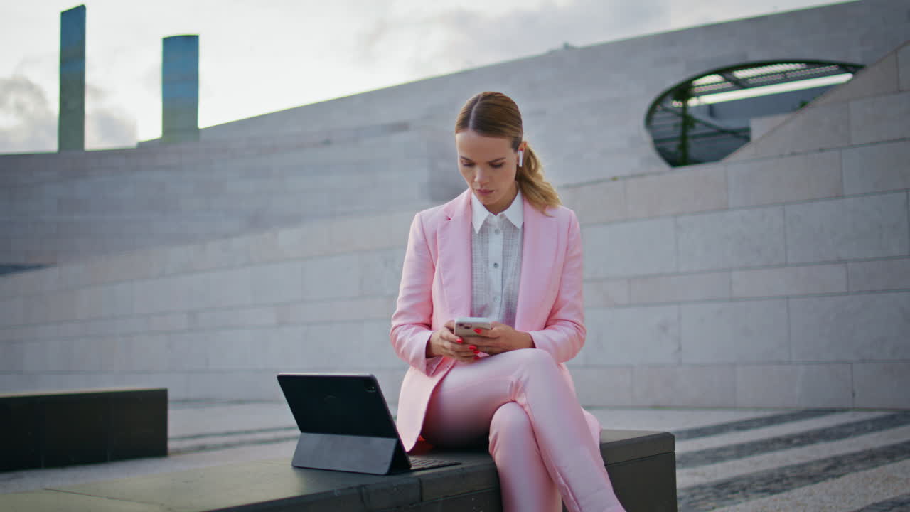 Woman specialist working remotely by tablet sitting bench. Lady looking laptop