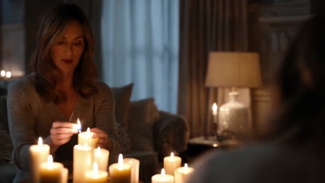 woman lighting candles in a dimly lit room