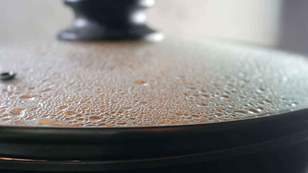Close-up of a steaming pot lid with condensation