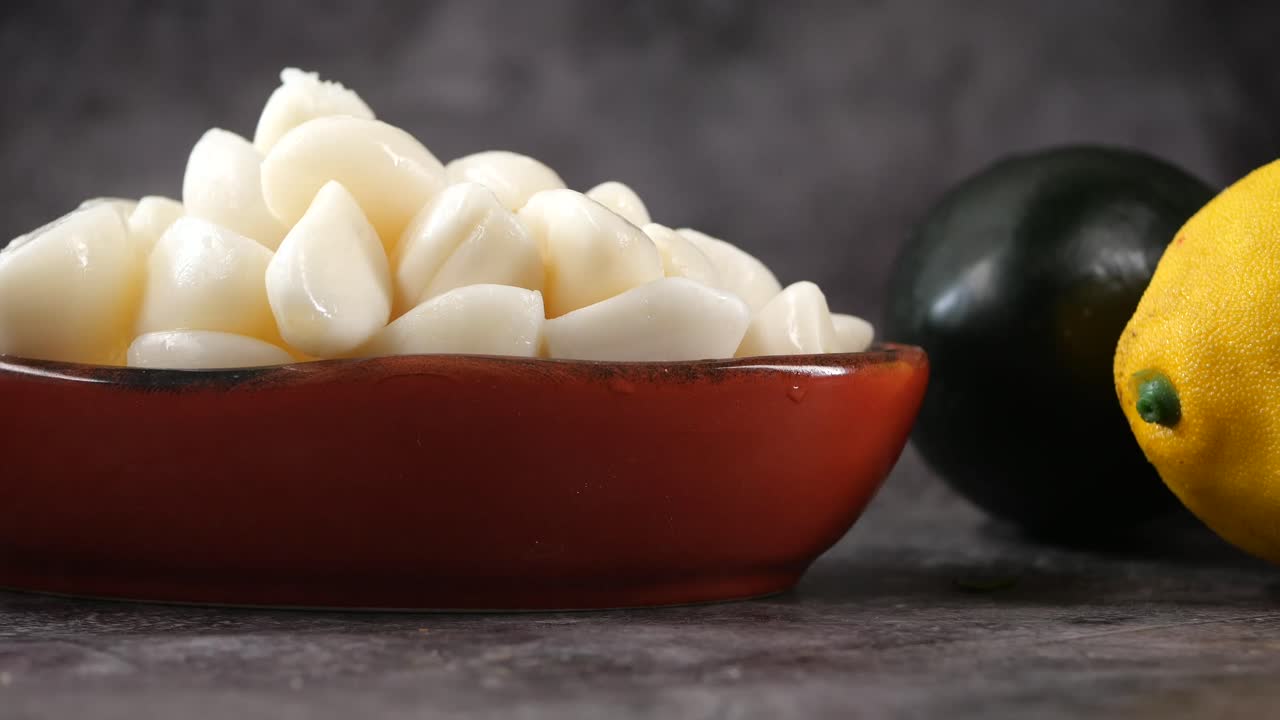 Spicchi d'aglio pelati in una ciotola con verdure fresche