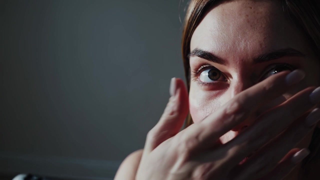 Giovane donna triste seduta da sola per terra in una stanza vuota