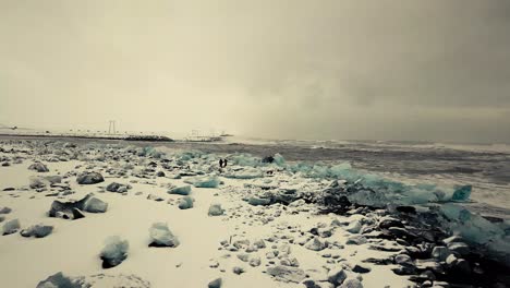 cinematic drone moves show black sand beach in iceland filmed by drone in snowy conditions