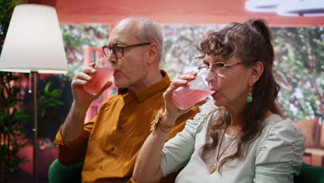 senior man and woman drinking fizzy effervescent vitamins with glasses of water