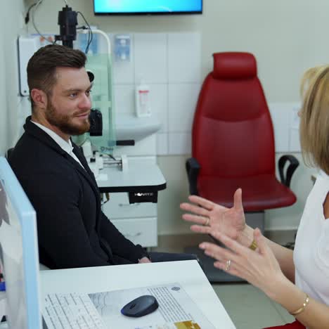 visit to ophthalmology clinic. oman ophthalmologist is recommending male client to measure eyesight. healthy eyes concept