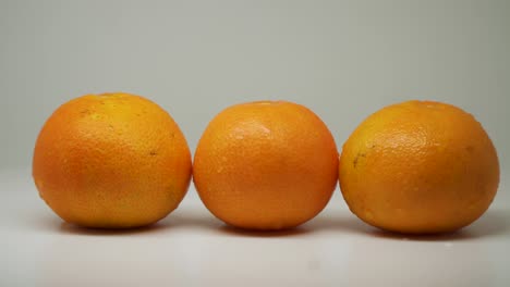 tres hermosos naranjas húmedos en un tocadiscos se ven bien y deliciosos - primer plano