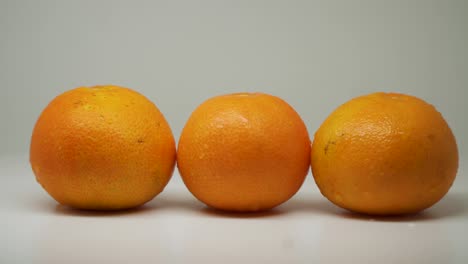 three beautiful wet orange in a turntable looks good and delicious - close up shot