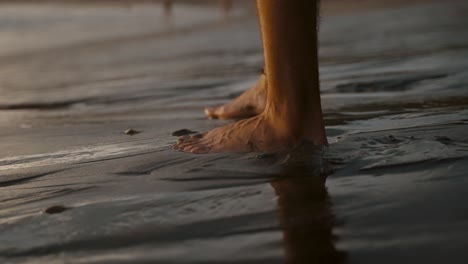 a man's bare feet on a muddy seashore