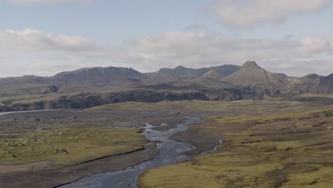 Vista-Aérea-Que-Muestra-El-Río-Glacial-Skafta-En-La-Zona-Volcánica-De-Islandia-Durante-El-Día-Nublado-Y-Soleado---Hermoso-Paisaje-De-Montaña-En-El-Fondo