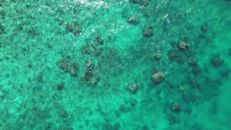 Eine-Drohne-Blickt-Auf-Klares-Türkisfarbenes-Wasser,-Das-über-Felsen-Fließt