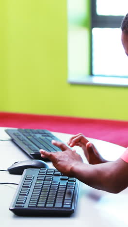 Schoolboy using computer in classroom