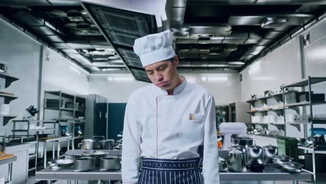 chef asiático con dolor de cabeza mientras está de pie en la cocina