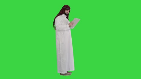 arabic business man with tablet on a green screen, chroma key
