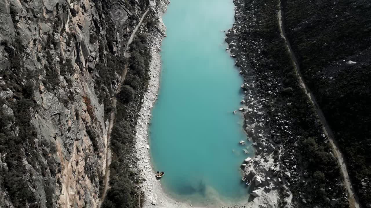 аэрофотосъемка над озером лагуна парон с бирюзовой водой в перуанских андах между горами и пиком пирамиды, место для треккинга в кордильера бланка, перу