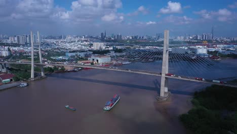 Luftaufnahme-Von-Phu-My-Bridge-über-Den-Saigon-River-Mit-Straßen--Und-Flusstransport-An-Einem-Sonnigen-Tag