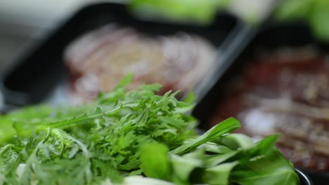 preparing a delicious soup with meat and green leafy ingredients - closeup shot