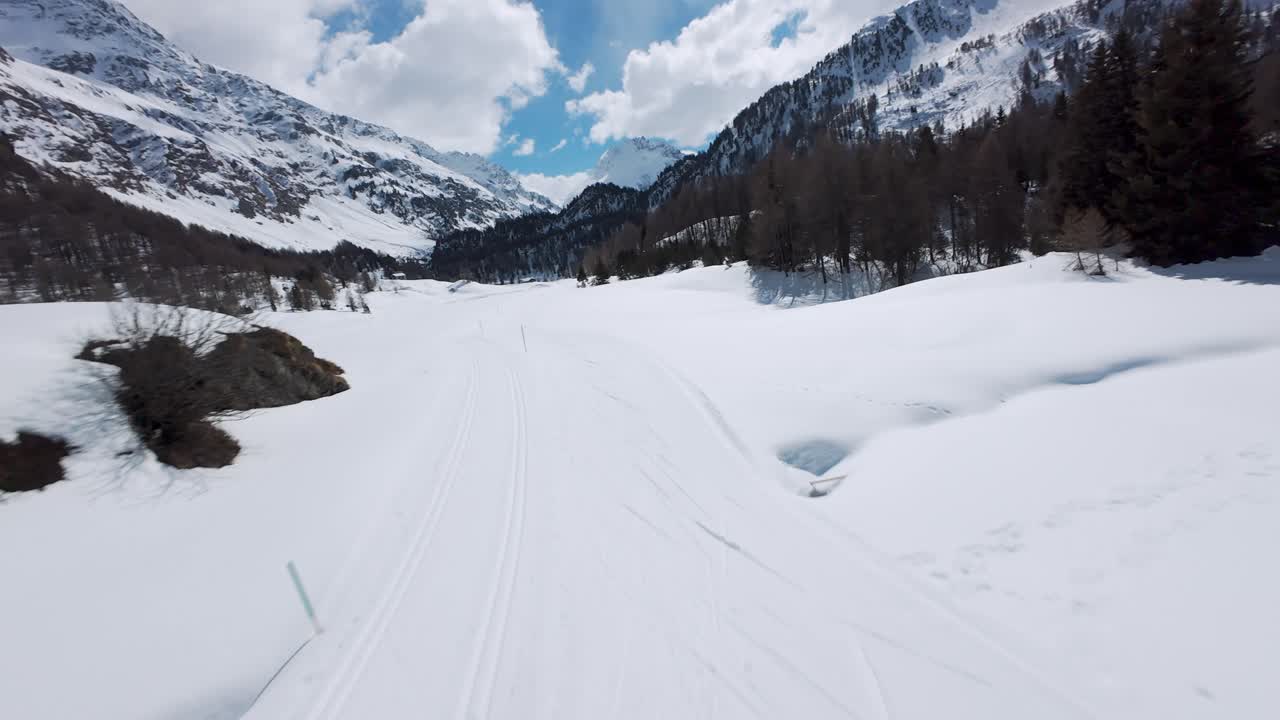 FPV drone sweeps over vast snowy plains, cars on winding mountain road near Cheneil, themes, winter travel, Italy