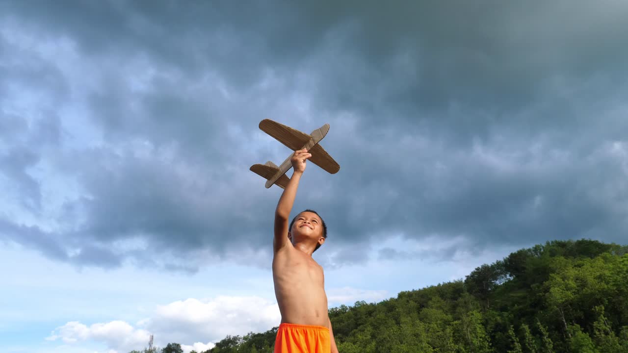 Boy playing with toy airplane outdoors