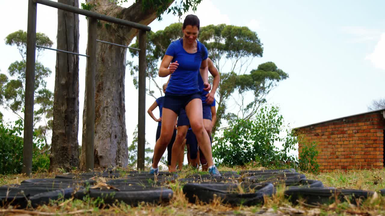 Fit people practicing tire obstacle course training 4k