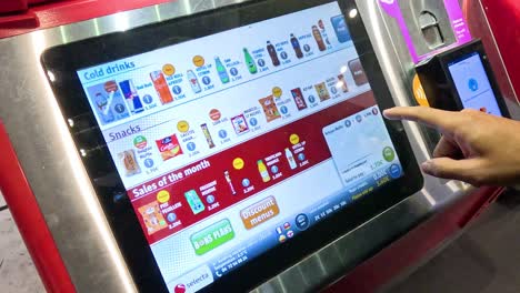 sequence showing a man selecting a drink on a touchscreen.