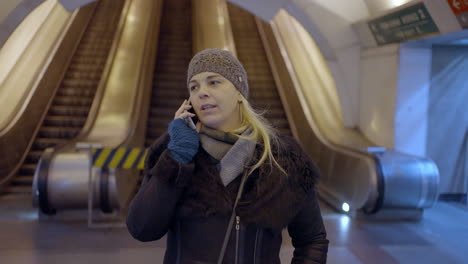 woman talking on the phone in a public transportation station
