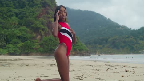 A-tropical-beach-on-Trinidad-features-a-young-girl-in-a-bikini-on-her-knees-in-the-sand