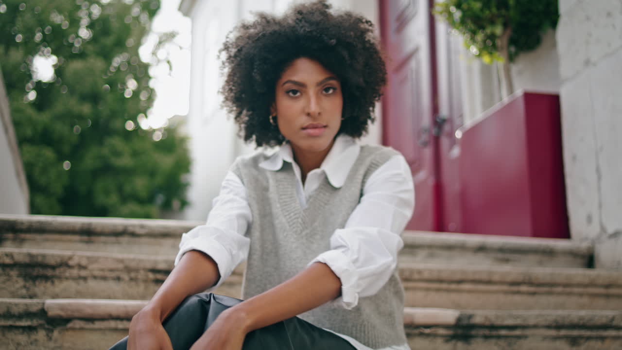 chica posando sentada en la escalera de la calle de la ciudad de cerca. mujer relajándose al aire libre.