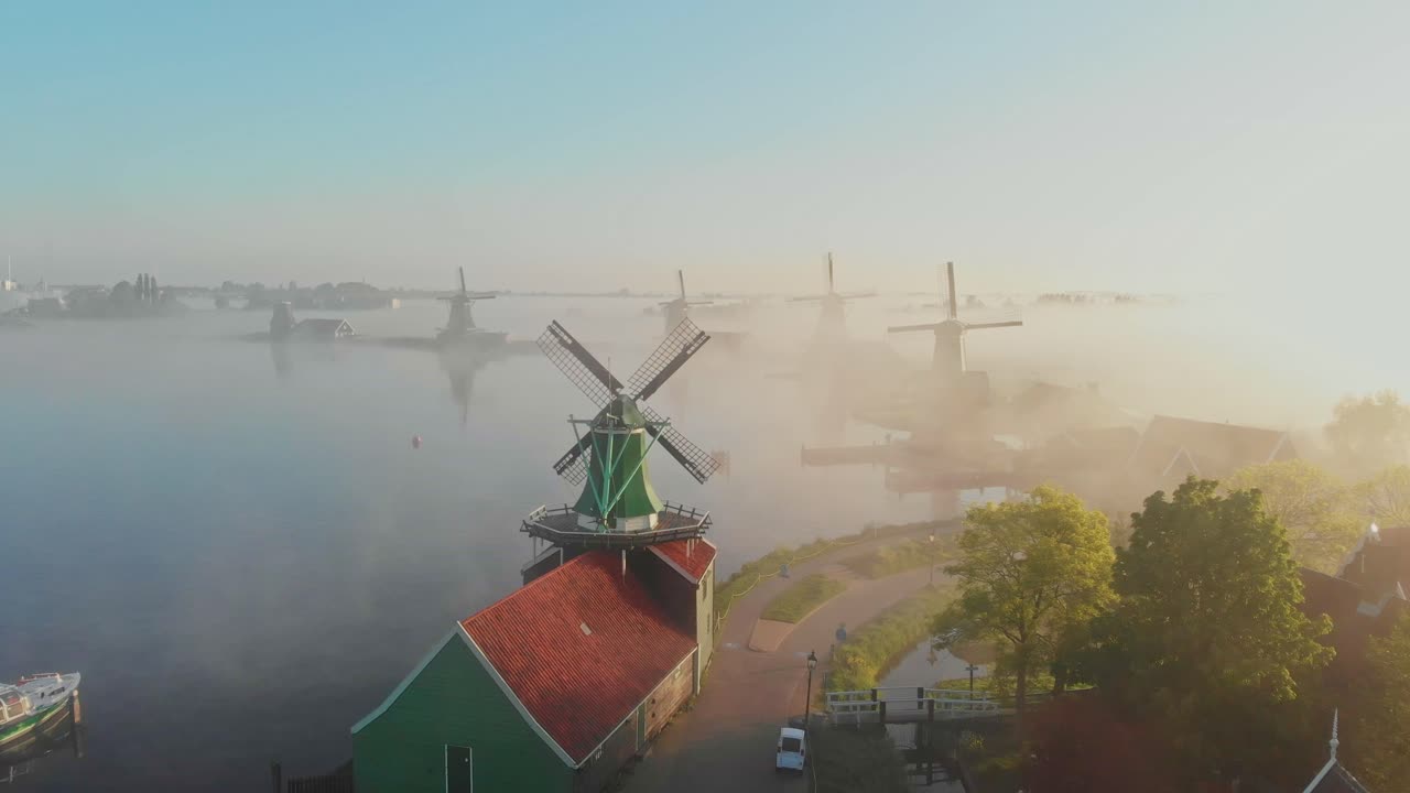 Vista aerea dell'iconico mulino a vento di Zaanse Schans che si erge nella nebbia mattutina all'alba nei Paesi Bassi