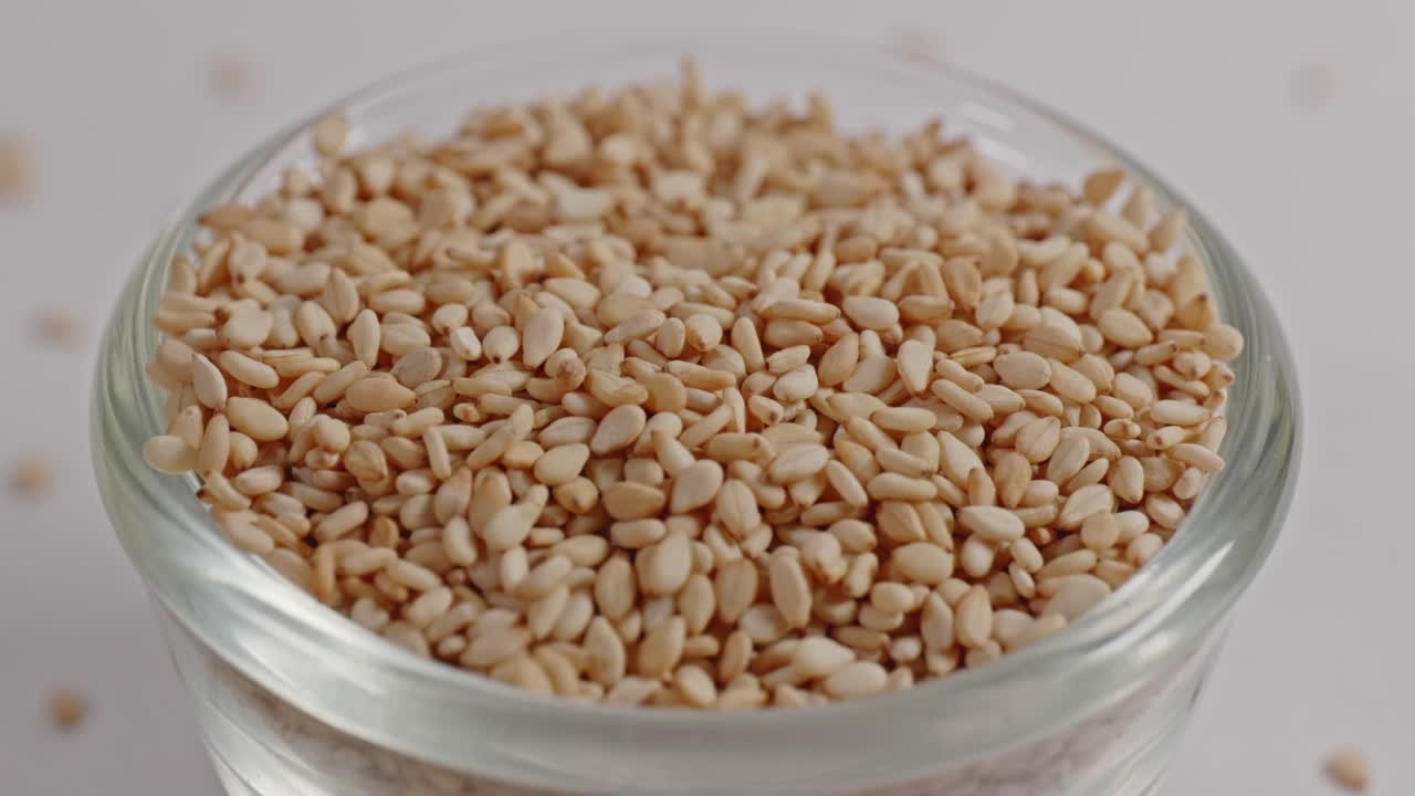 sesame seeds in small glass bowl, closeup, 4k, parallax shot.