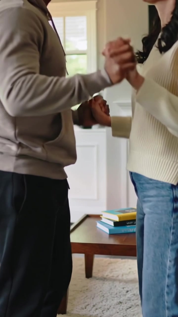 Video verticale: Mani che si tengono, uomo con felpa con cappuccio che inizia vicino, cambiando la presa e ondeggiando vicino alla porta, innamorati