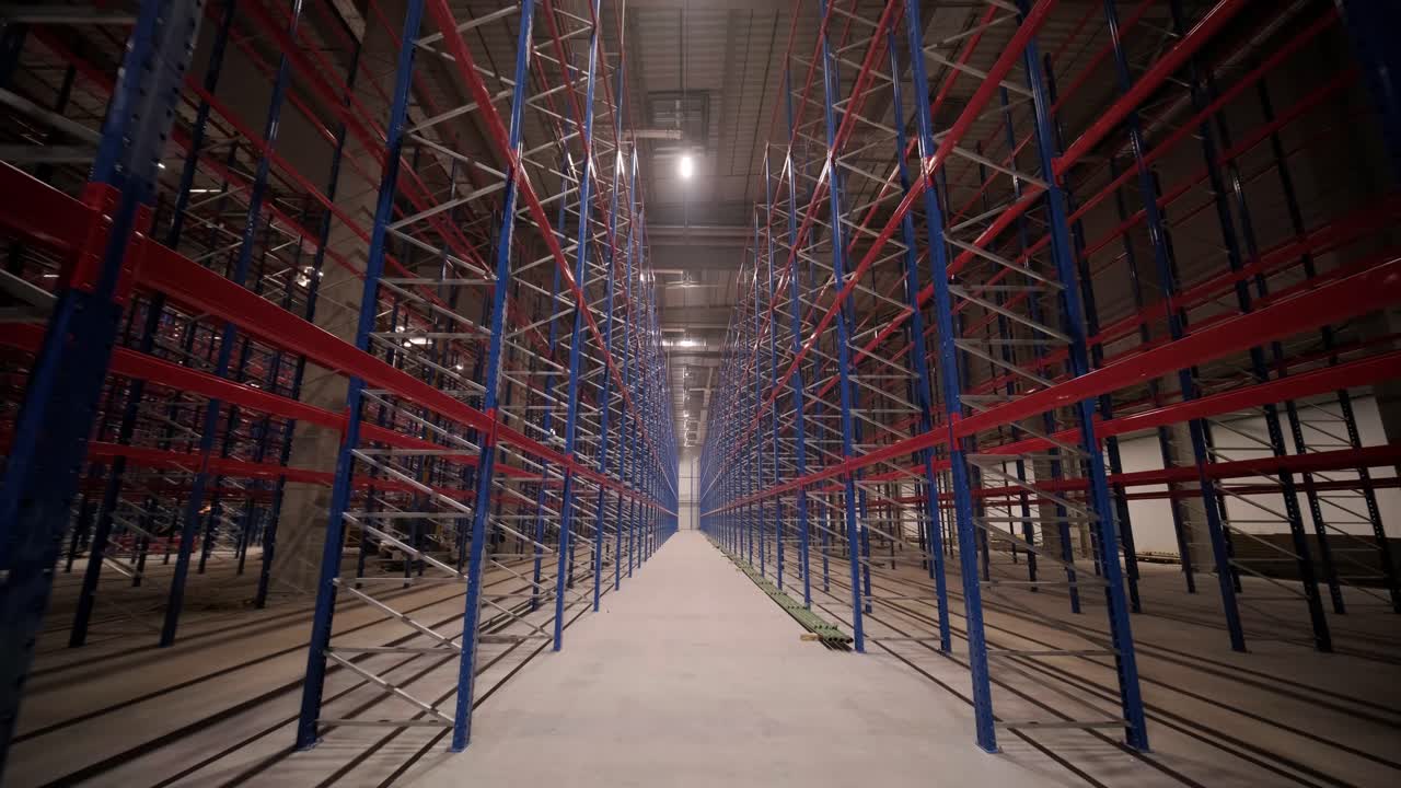 gran y moderno almacén en construcción, con estanterías metálicas y otros equipos industriales.