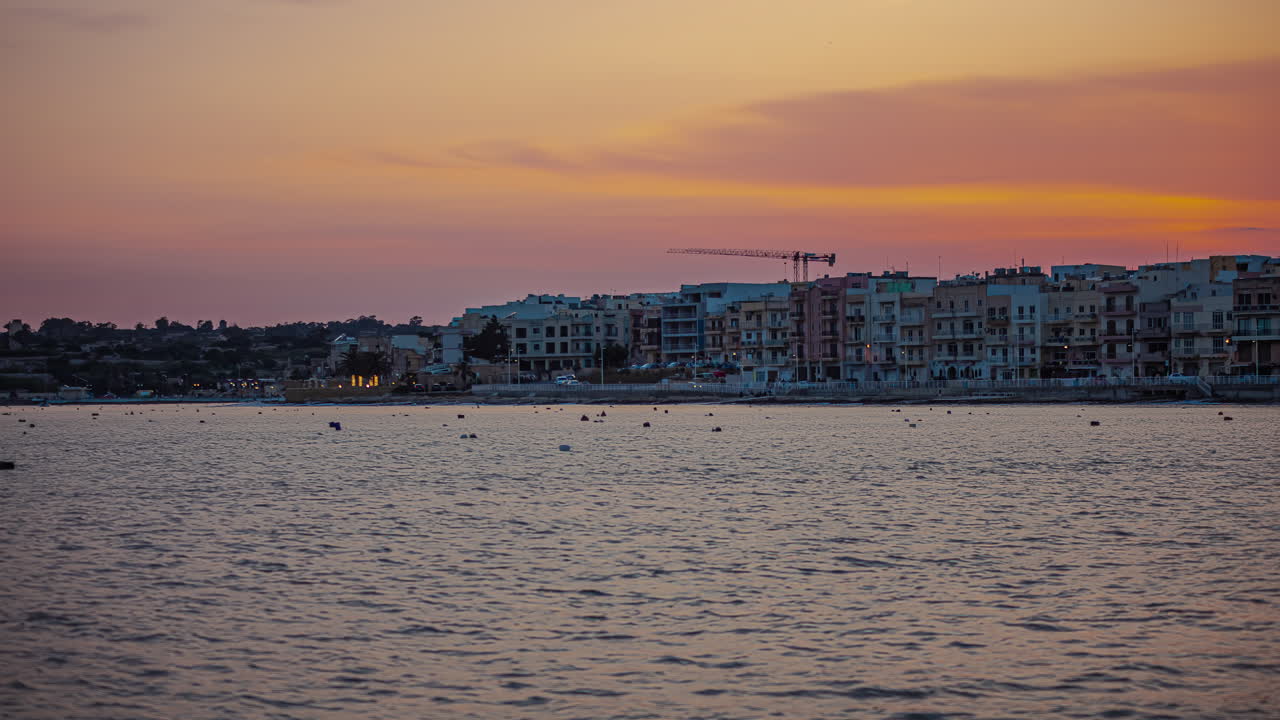edificios de la ciudad costera de gzira, malta como el cielo al atardecer se desvanece al anochecer, timelapse