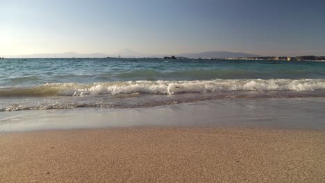 Slow-motion-low-angle-slider-over-sandy-beach-with-Mt