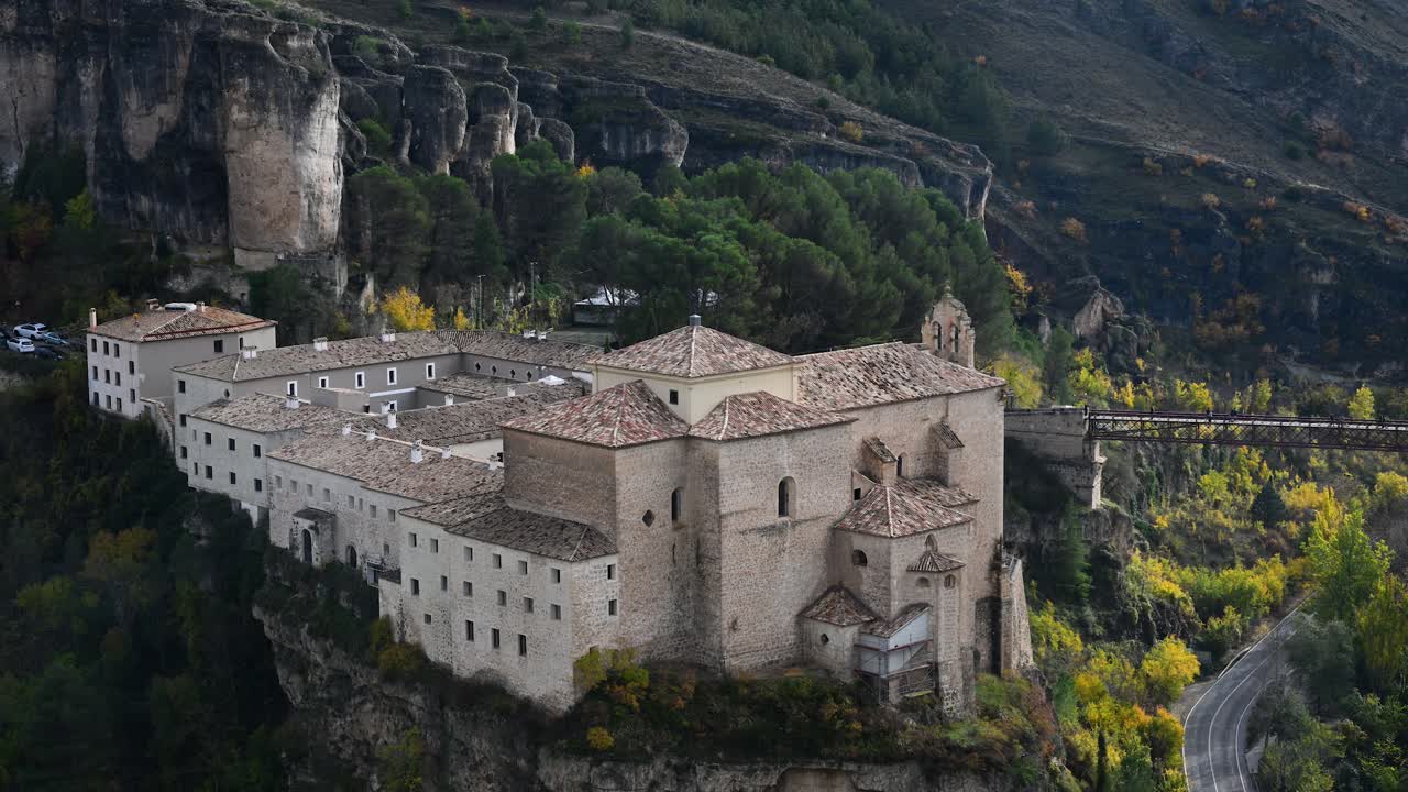 CUENCA, SPAIN - A stunning autumn view of the Parador de Cuenca (former Convent of San Pablo) perched on a cliff above the winding roads of the Huecar gorge.